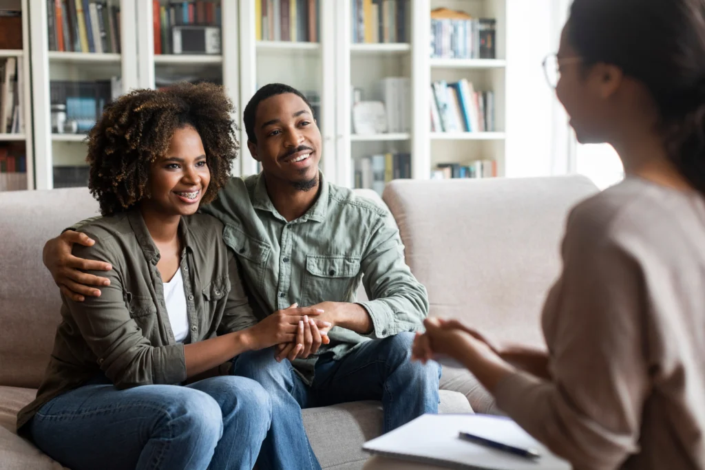 Couple engaged in premarital counseling session with therapist, discussing relationship dynamics and building a strong foundation for marriage.